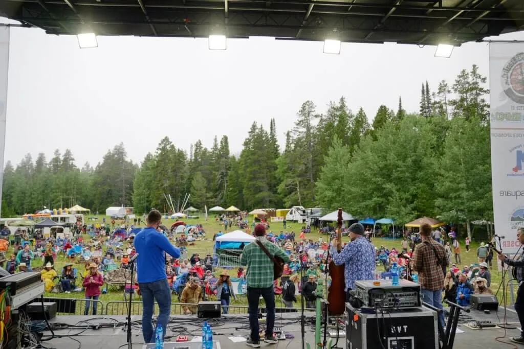 Audience watching a band perform at the Beartrap Summer Festival in Casper, Wyoming mountain meadow
