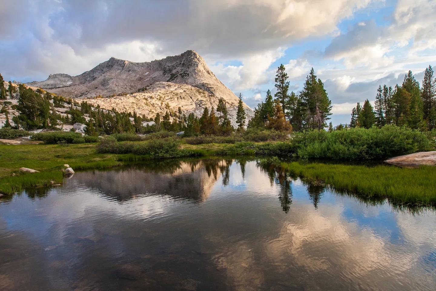 Backpacker hiking towards a distant mountain range in Yosemite's high country
