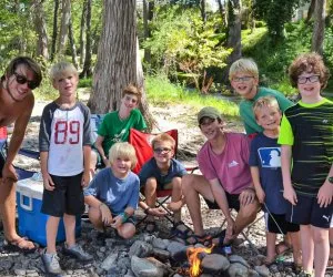 Boys participating in a low ropes course or climbing activity at a Texas summer camp