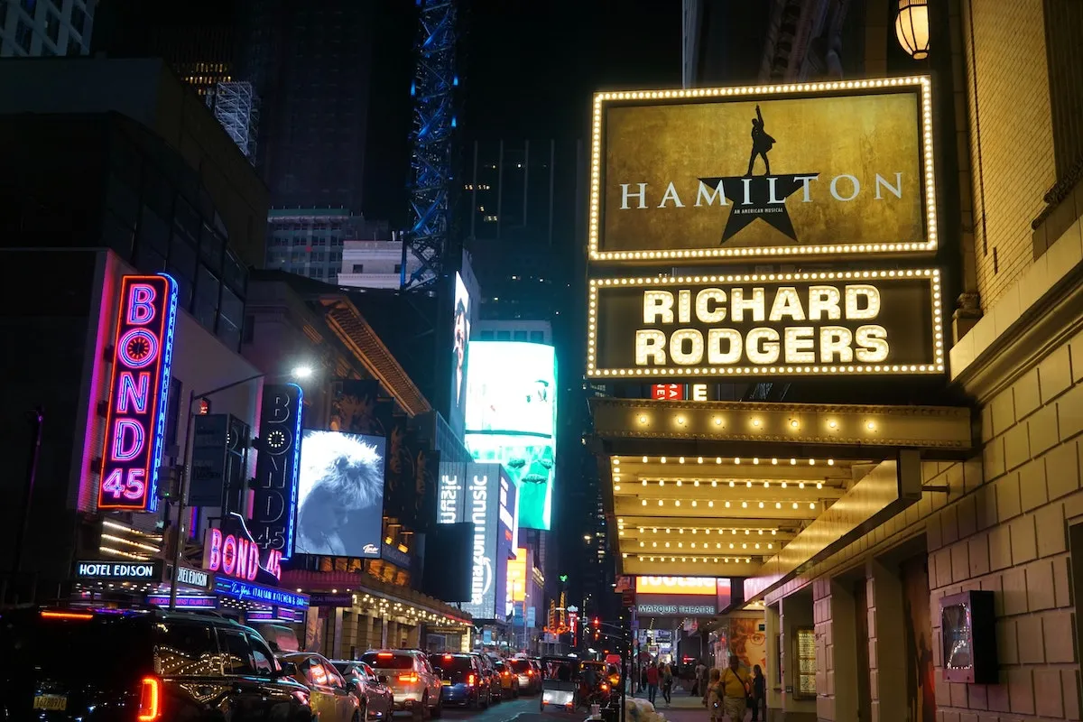 Broadway theater marquee lit up at night in New York City, a must-do activity when going out in new york.