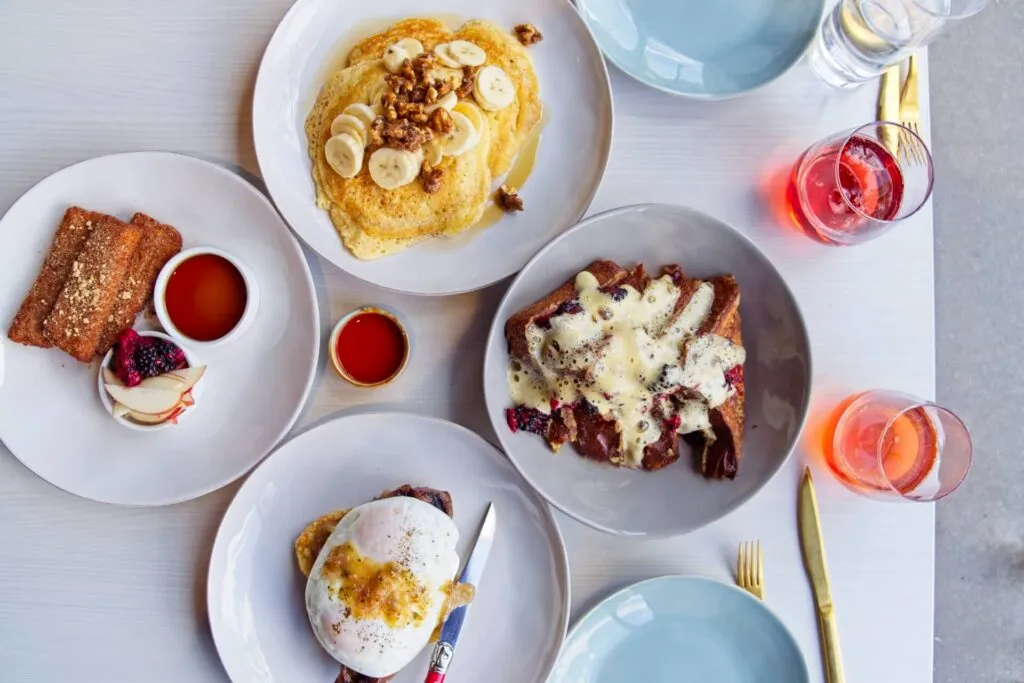 Brunch spread including Steak and Eggs and Soufflé Pancakes at the now-closed Rooted Craft Kitchen, formerly a popular brunch spot in Denver.