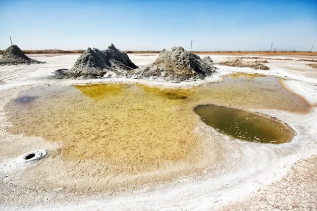 Bubbling mud pots in a flat, barren landscape