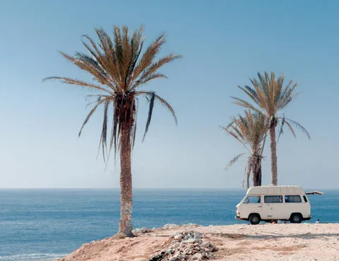 Camper van parked by trees, illustrating safe overnight parking options.