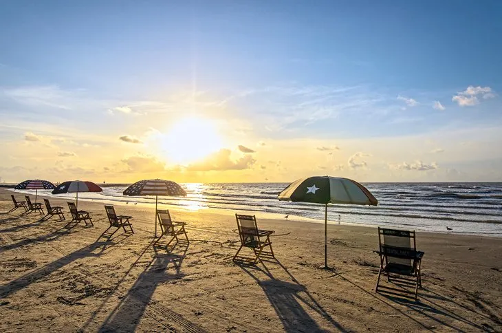 Chairs set up on a wide beach in Galveston, Texas.