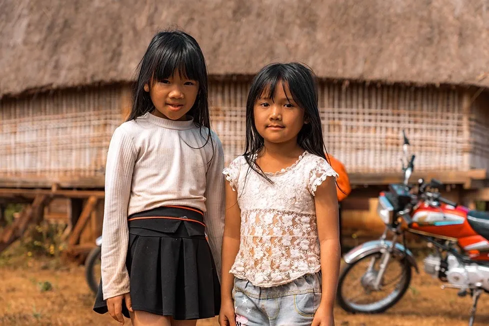 Children playing and smiling in a village in Vietnam.