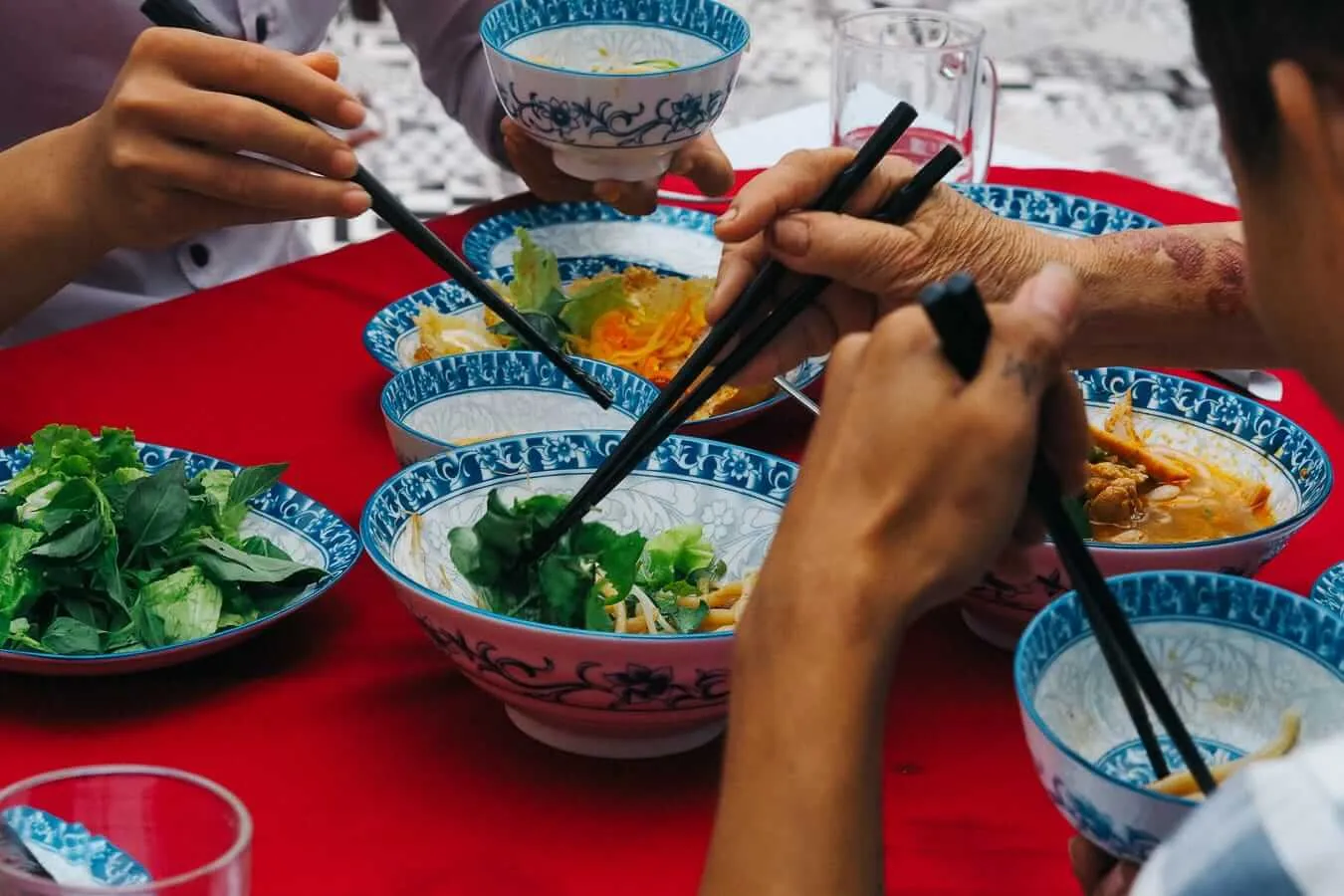 Chopsticks dive into a shared meal of Hoi An speciality dishes. Photo: Agnuush Monstar