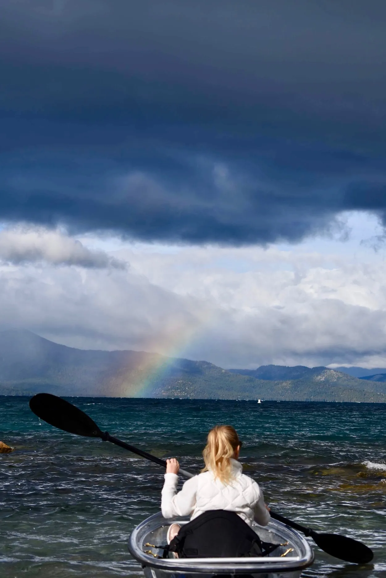 Clear kayaks pulled up on a beach at Lake Tahoe