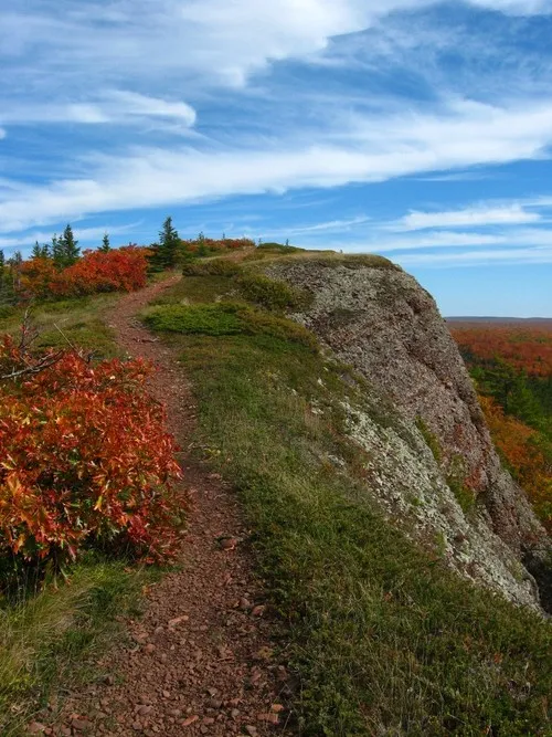 Climbing a rocky trail on Mt. Baldy, an ascent offering rewarding views for those who explore the Upper Peninsula's natural landscape.