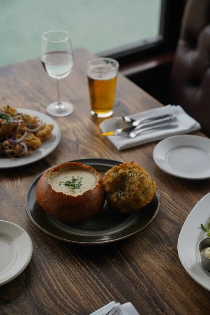 Close-up of a bowl of clam chowder in a sourdough bread bowl with crackers at Old Fisherman's Grotto in Monterey
