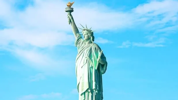 Clouds behind the Statue of Liberty seen from a distance in New York Harbor