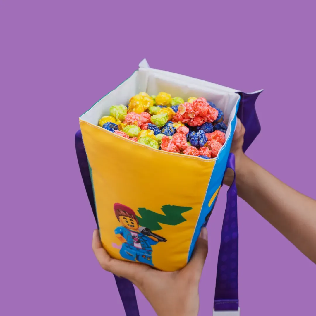Colorful candied popcorn in a branded bucket.