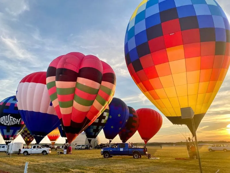 Colorful hot air balloons lifting off at the Battle Creek Field of Flight Festival