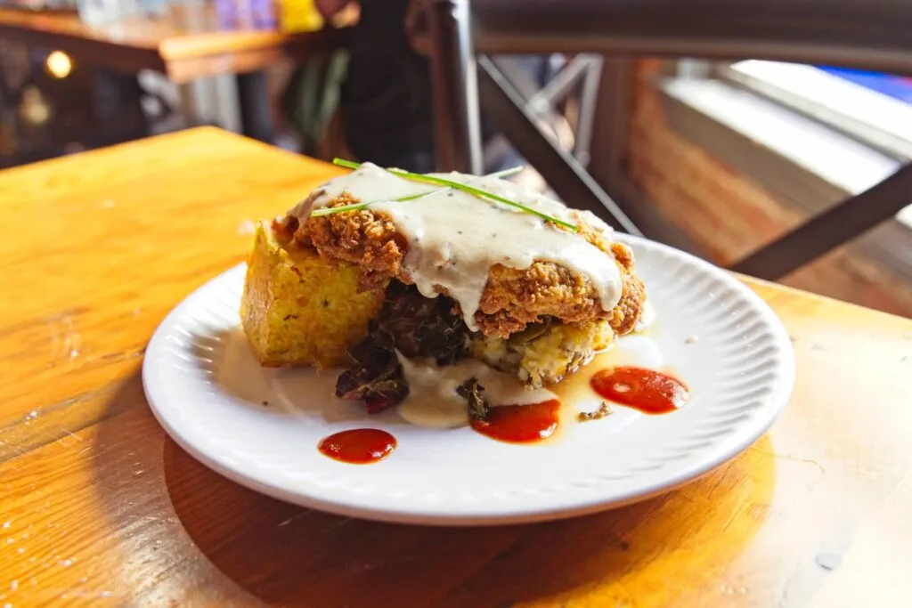 Country Fried Steak smothered in duck fat gravy served with collard greens and potato casserole at Sassafras, a Southern-style brunch favorite in Denver.