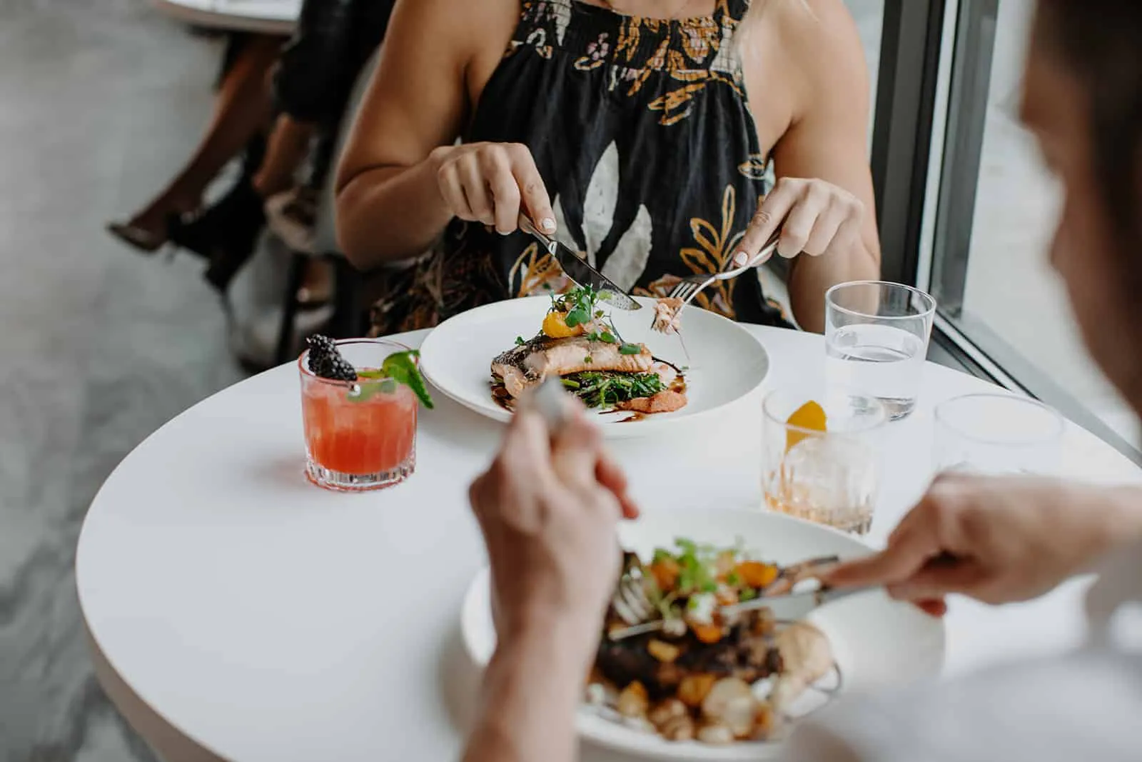 Couple eating at a table at Lumen8 Rooftop Social, one of the best restaurants in colorado springs.