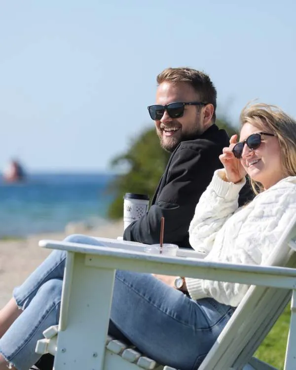 Couple enjoying a walk on the beach with the Mackinac Bridge in the distance