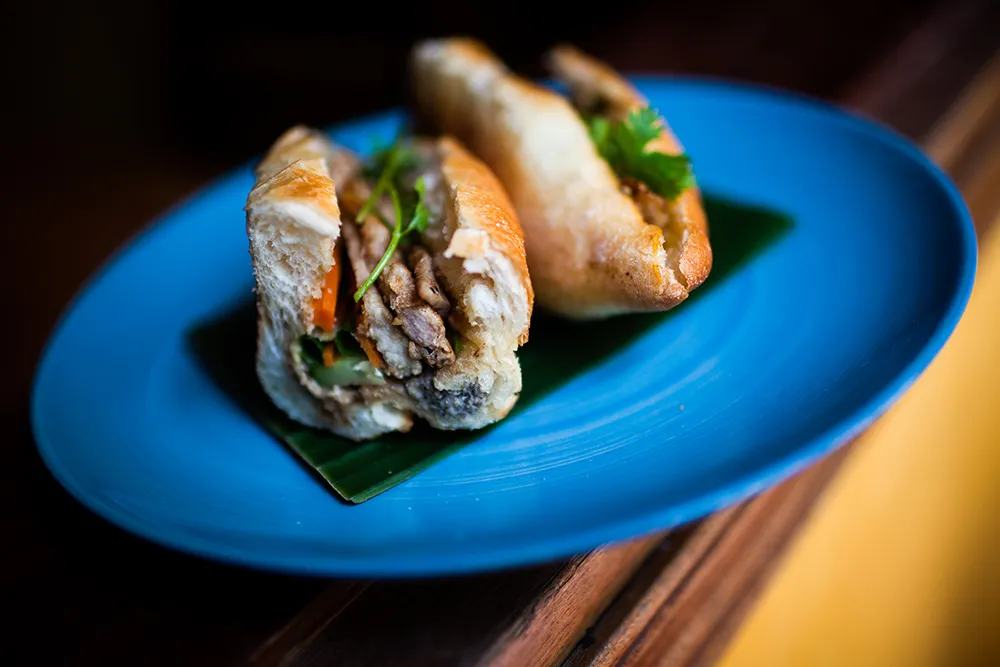 Crispy Vietnamese Banh Mi sandwich filled with pork, herbs, and pickled vegetables