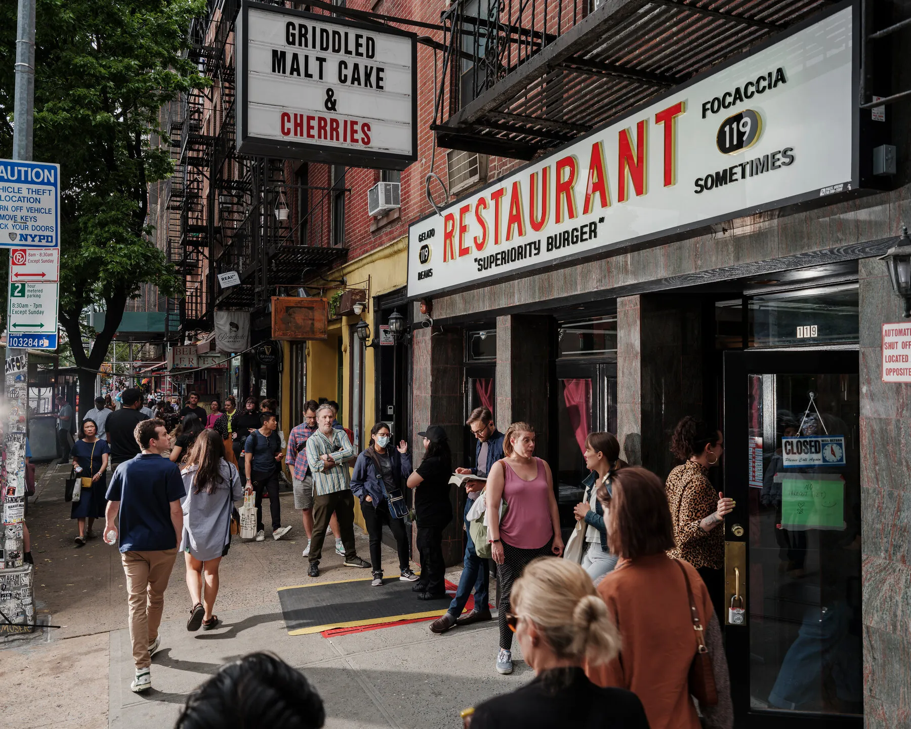 Customers waiting outside Superiority Burger, a popular vegetarian spot in the East Village known for its unique plant-based menu.