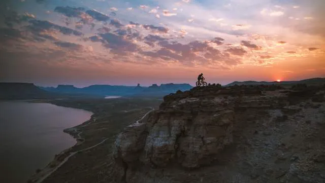 Cyclist riding along a dirt trail with views of Flaming Gorge in Sweetwater County, Wyoming.