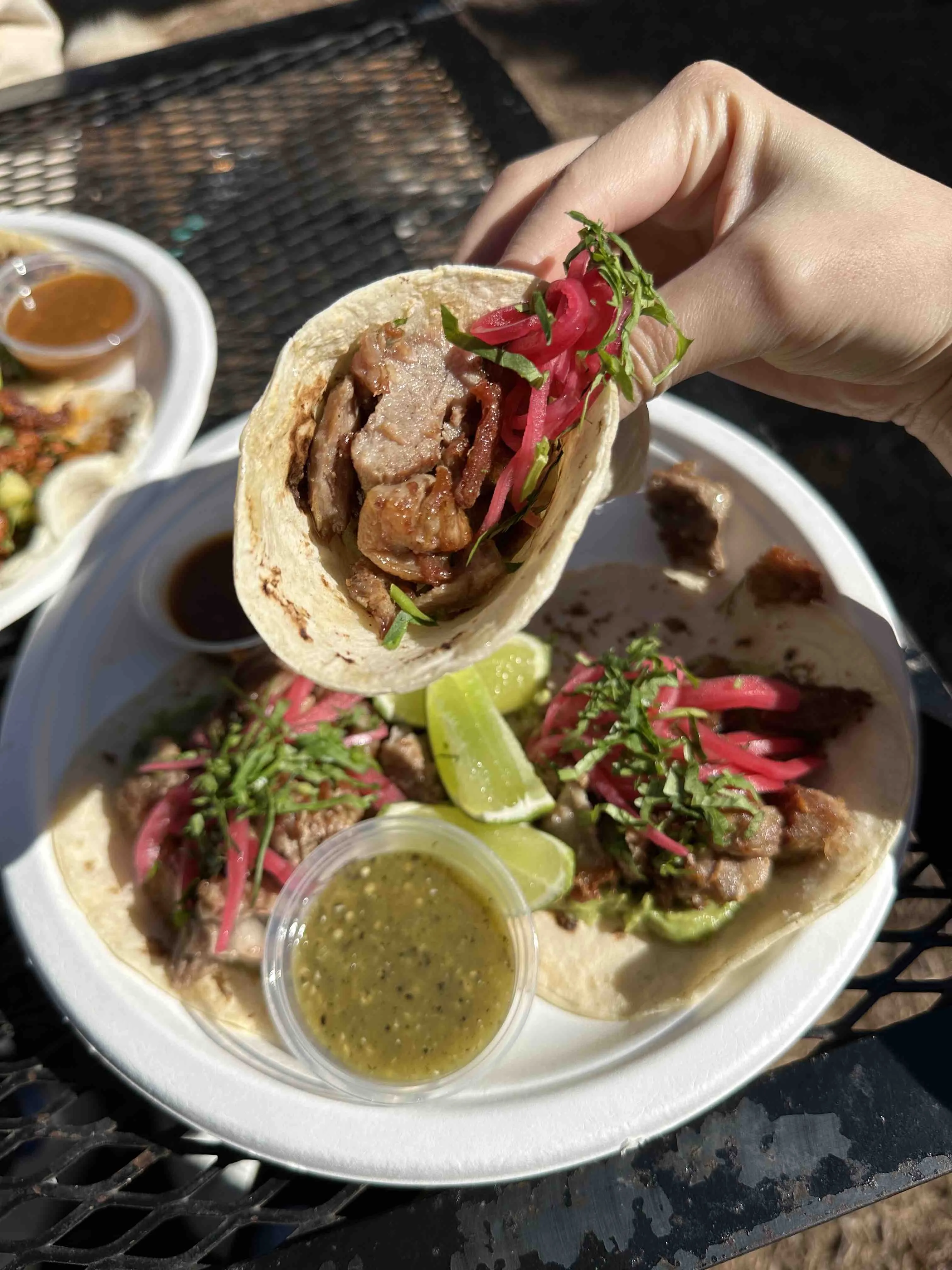 Delicious carnitas taco topped with pickled onions and avocado from Un Mundo De Sabor