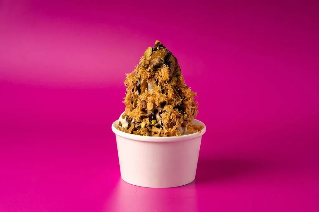 Dubai chocolate ice cream sundae in a cup from Sweet Graffiti on a pink background
