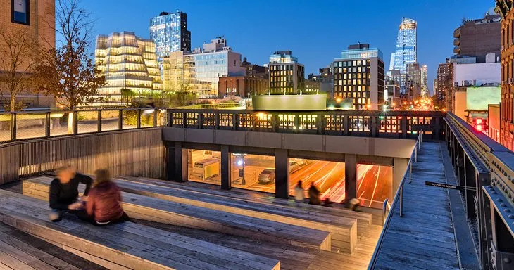 Elevated walking path of The High Line urban park at night, looking south.