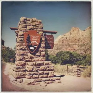 Entrance sign for Zion National Park, Utah, marking a significant stop for the girl from road trip