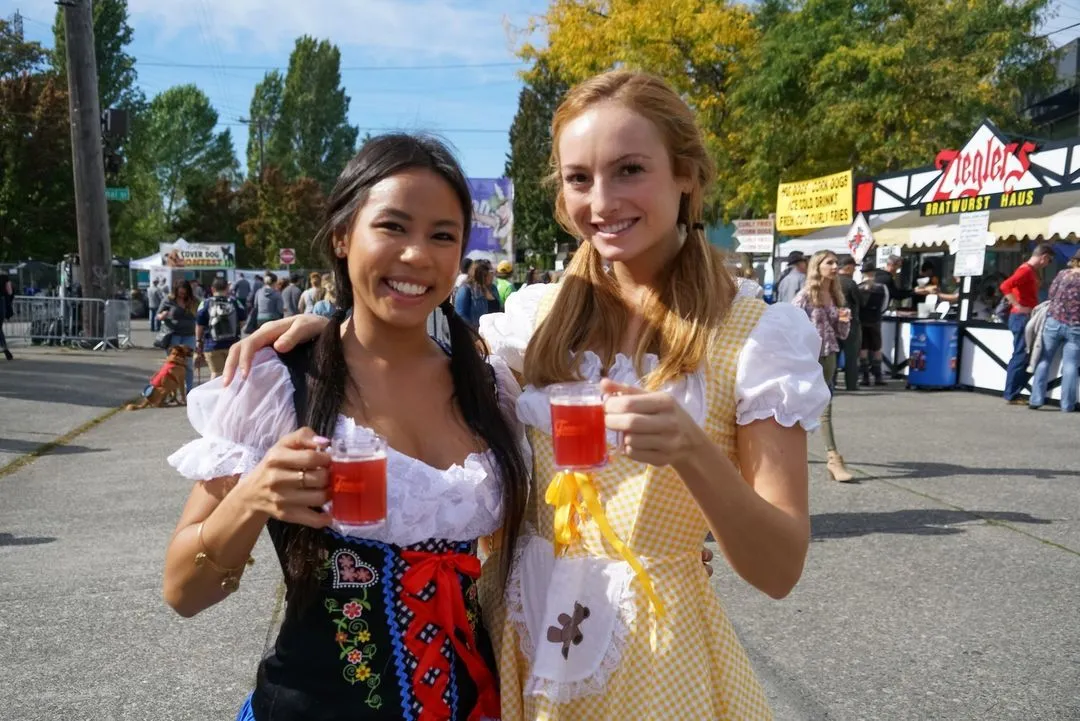 Excited crowd raising beer steins at Fremont Oktoberfest, Seattle's largest beer festival.