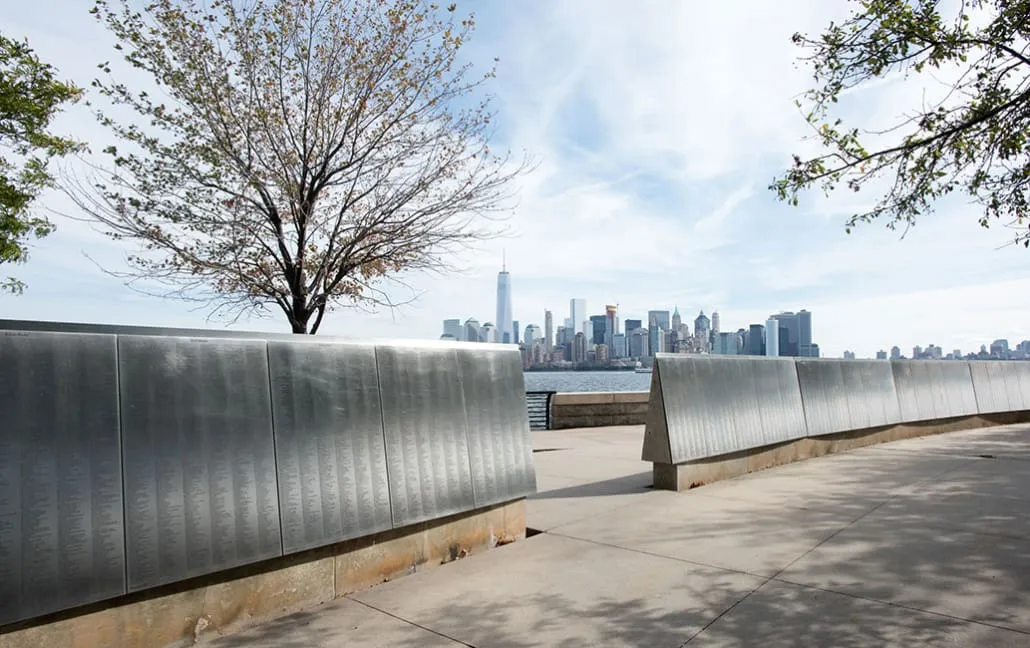 Exterior view of Ellis Island with immigrant names displayed in the park, relevant for those researching during a freiheitsstatue besichtigen visit