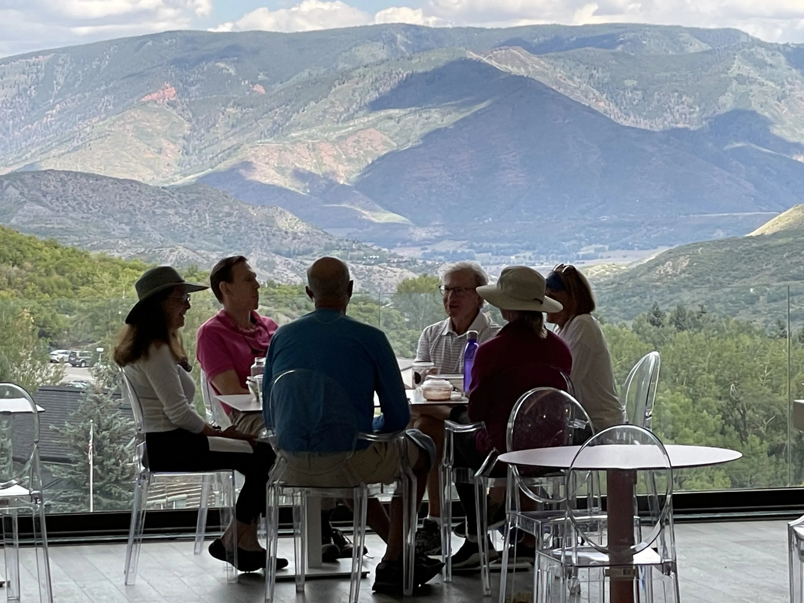 Exterior view of Jüs Snowmass building with mountain backdrop