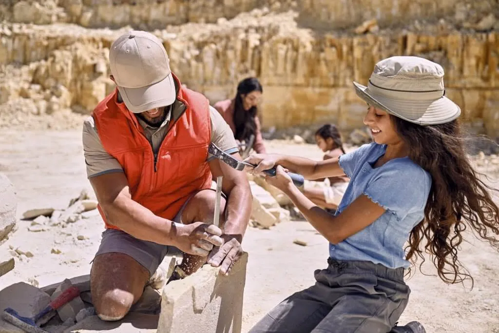 Family digging for fossils near a rock formation at Fossil Lake - Educational Things To See And Do In Wyoming