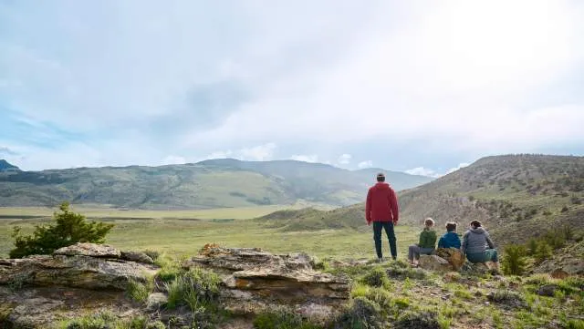 Family hiking with mountain backdrop in Wyoming wilderness