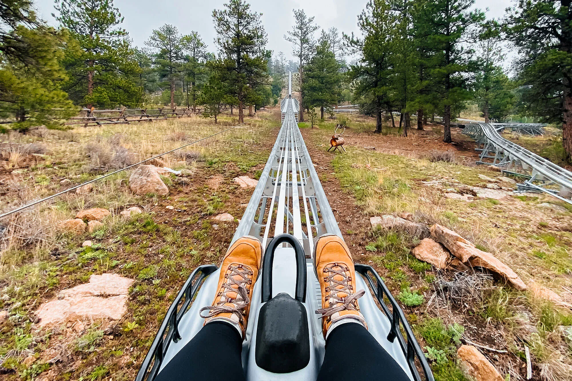 Feet on alpine coaster track with mountain view in Estes Park, Colorado