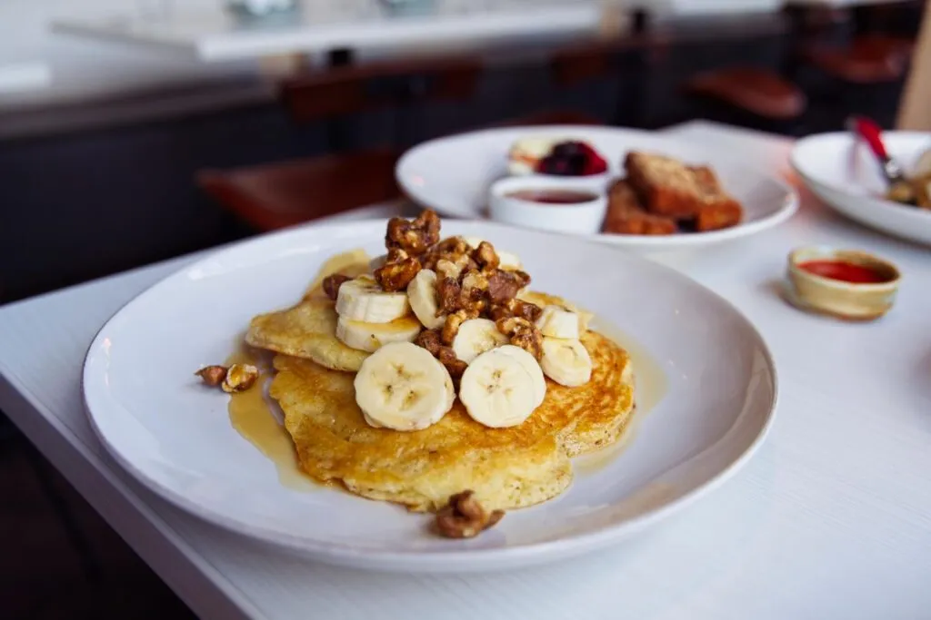Fluffy Soufflé Pancakes with candied walnuts and banana slices at the former Rooted Craft Kitchen, a memorable brunch dish in Denver.