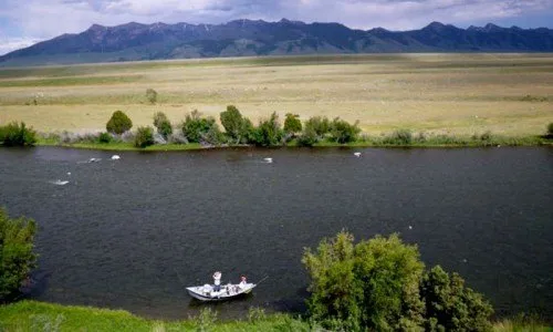 Fly fishing on a river during a couples retreat trip to Montana.