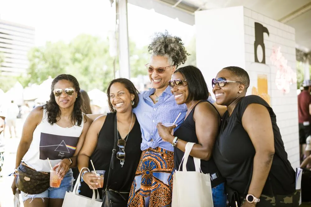 Four people, including a chef in uniform, pose for a photo at the austin food and wine festival