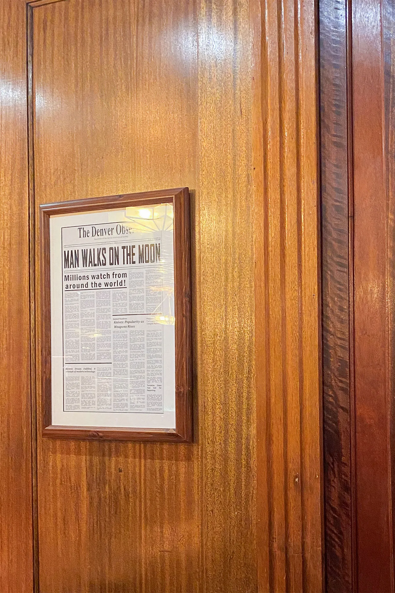 Framed newspaper clipping of 'Man Walks on the Moon' hanging on the wall in the Stanley Hotel Bar, Estes Park