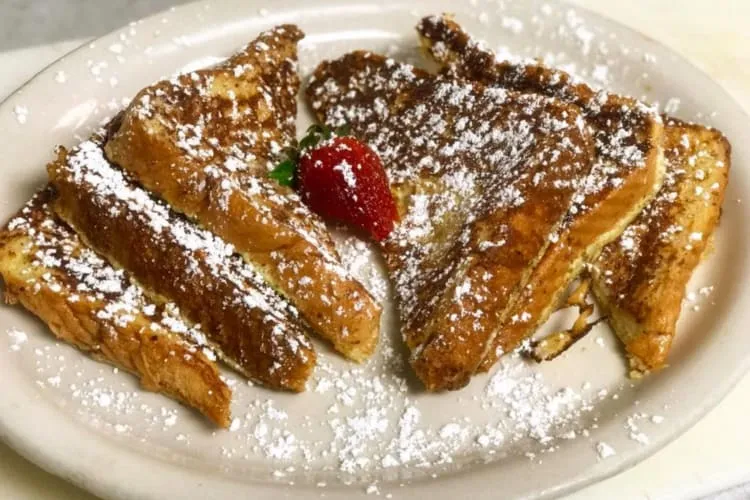 French toast garnished with strawberries and powdered sugar