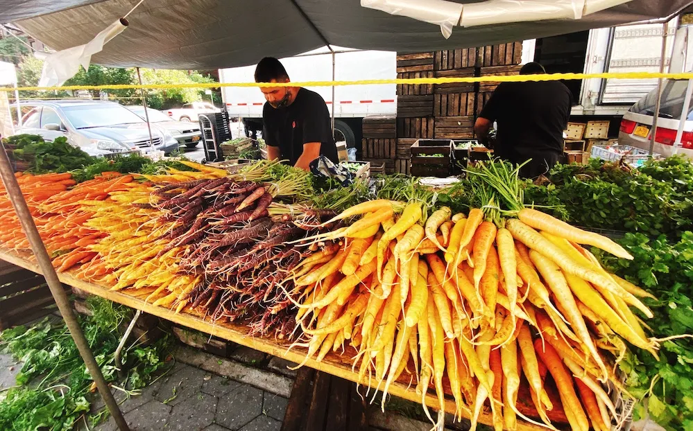 Fresh produce and flowers at the Fort Greene Park Greenmarket, one of the many unique farmer's markets in Brooklyn.