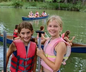 Girls participating in an archery activity at a summer camp in Texas
