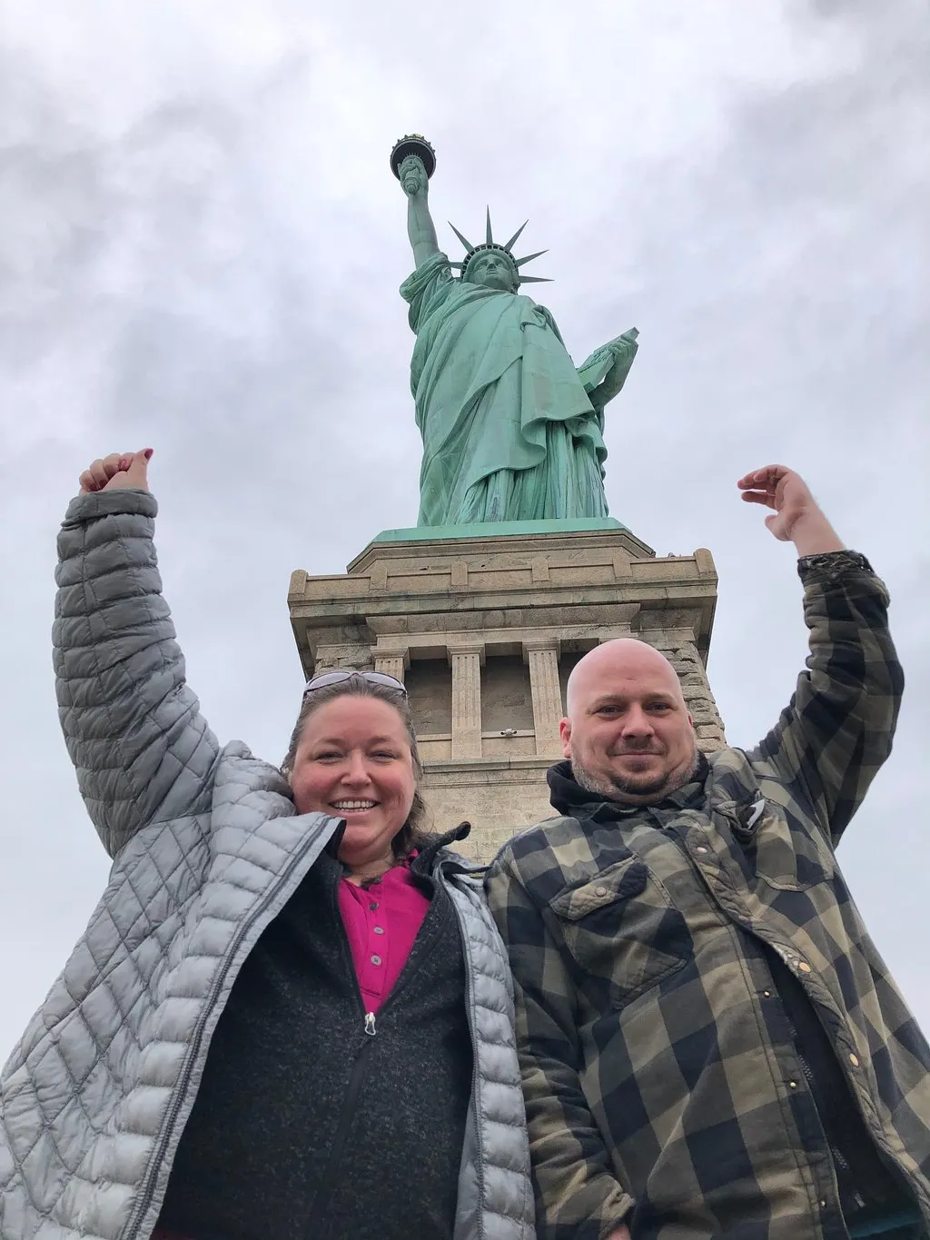 Group of people posing for a photo in front of the Statue of Liberty, likely on Fort Wood