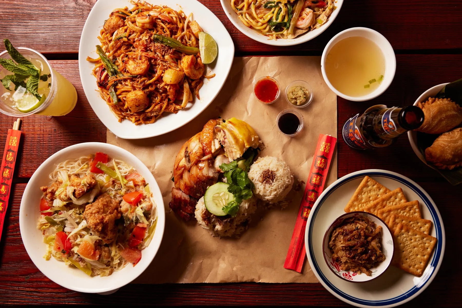 Hainanese chicken rice served with various accompaniments and sauces on a tray.