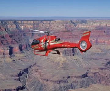 Helicopter soaring above the majestic rim of the Grand Canyon
