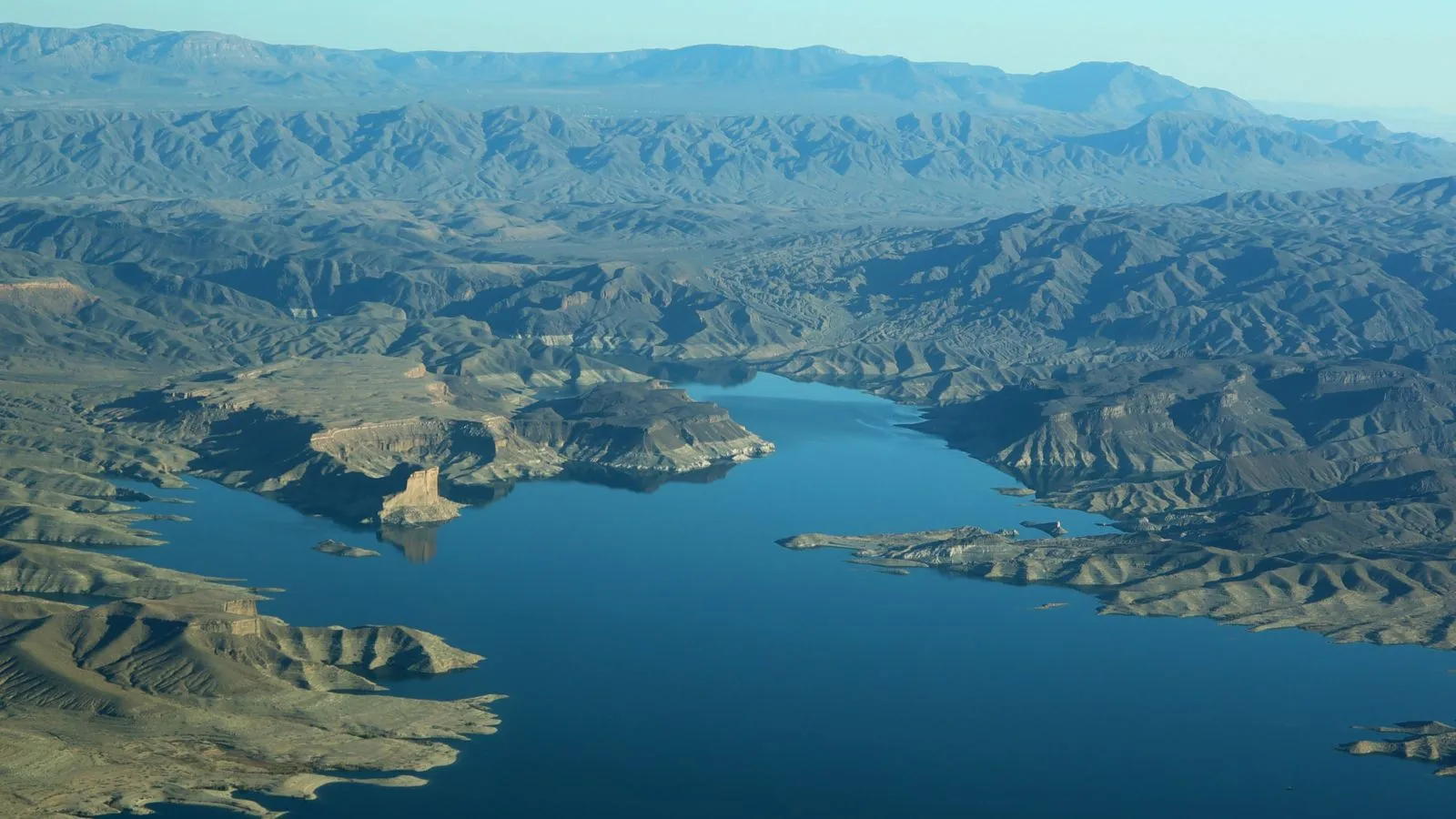 High aerial perspective of Lake Mead, showcasing its vastness and the surrounding arid landscape on a helicopter tour route.