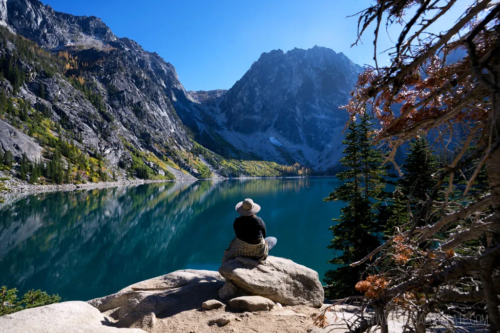 Hiker enjoying the view at Colchuck Lake during larch season