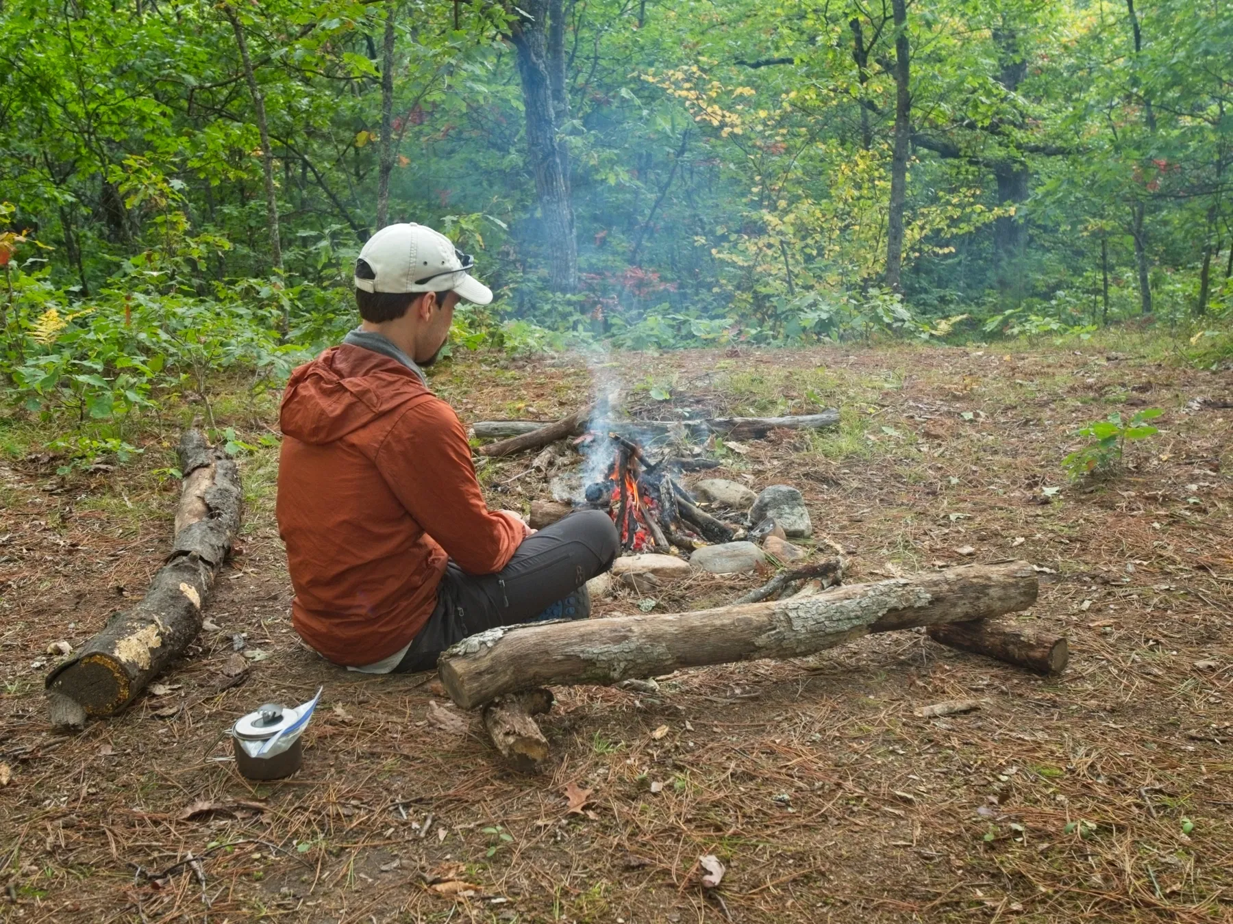 Hiker looking into the flames of a campfire