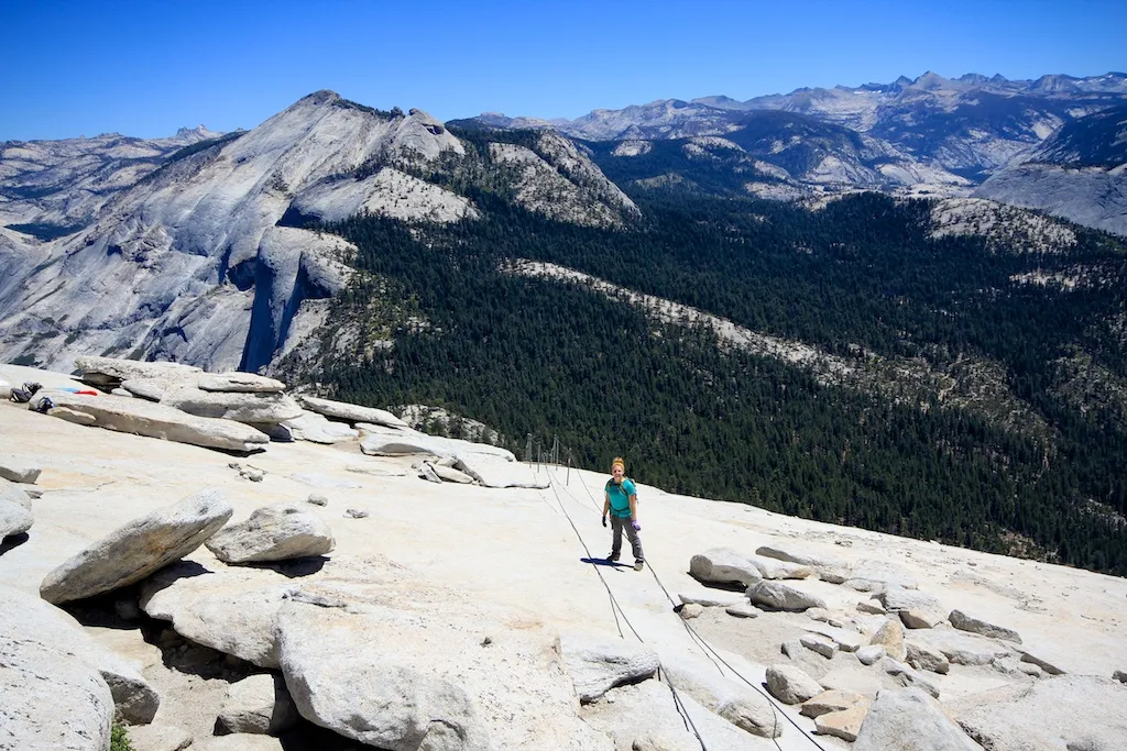 Hikers ascend the famous cables on the steep granite face of Half Dome in Yosemite National Park