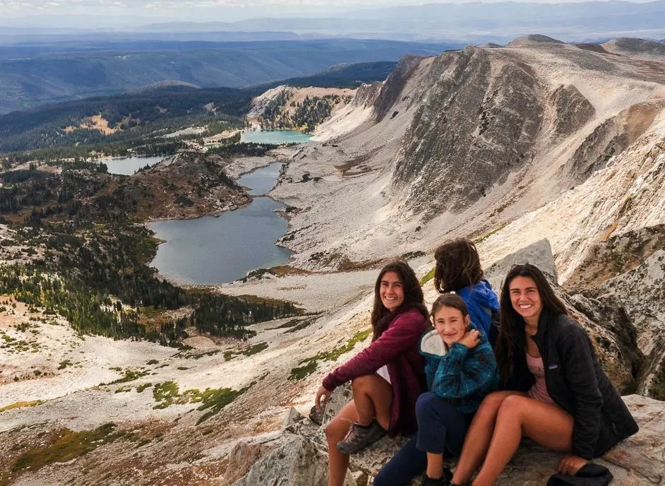 Hikers on the summit of Medicine Bow Peak, enjoying panoramic views of the surrounding Wyoming landscape