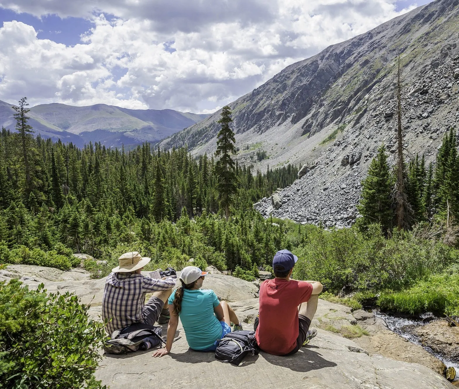 Hikers resting on a rock with mountain views on a trail in Breckenridge Colorado