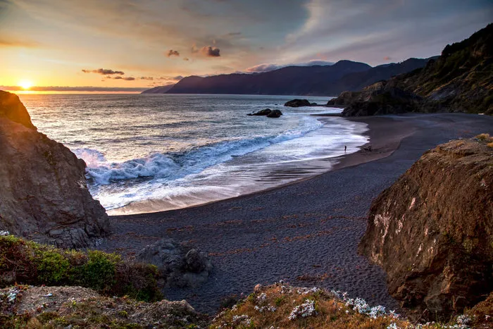 Hikers walk along the beach section of the Lost Coast Trail during a backpacking adventure in Northern California
