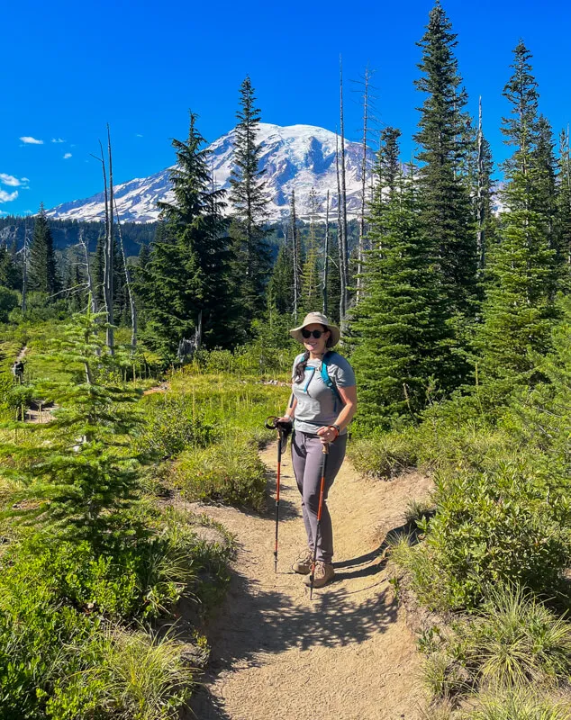 Hiking trail winding through wildflower meadows with Mount Rainier in the background